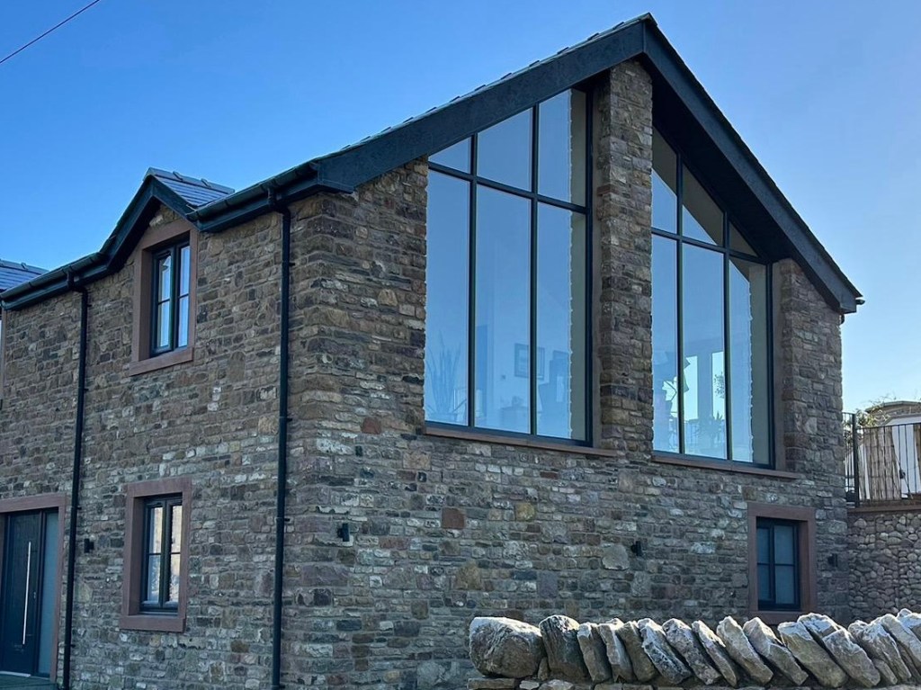 Detail showing the end gable with large picture windows on a new build 5 bed house in Morland, Penrith, Cumbria
